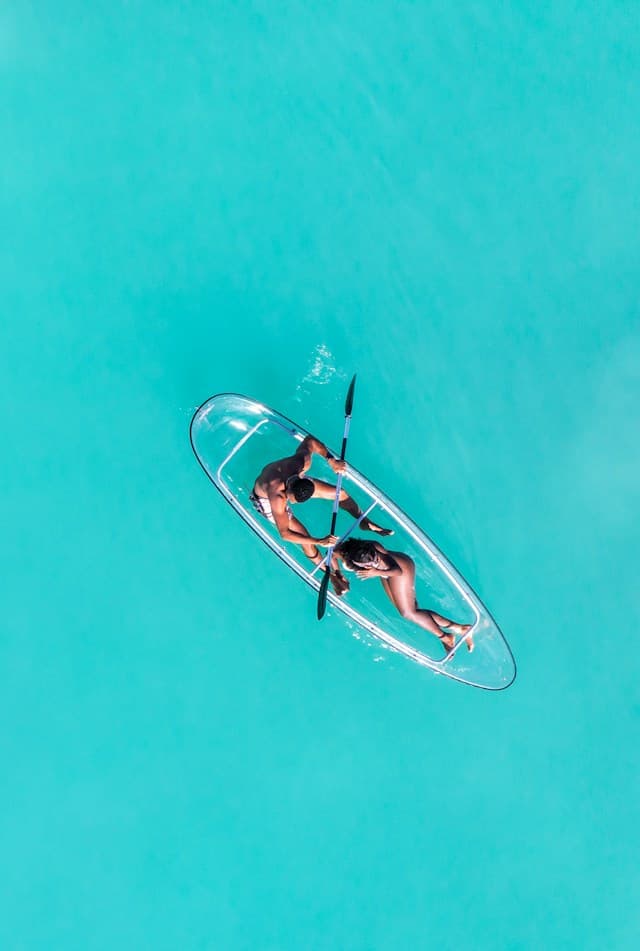 Woman paddling a kayak on clear turquoise water