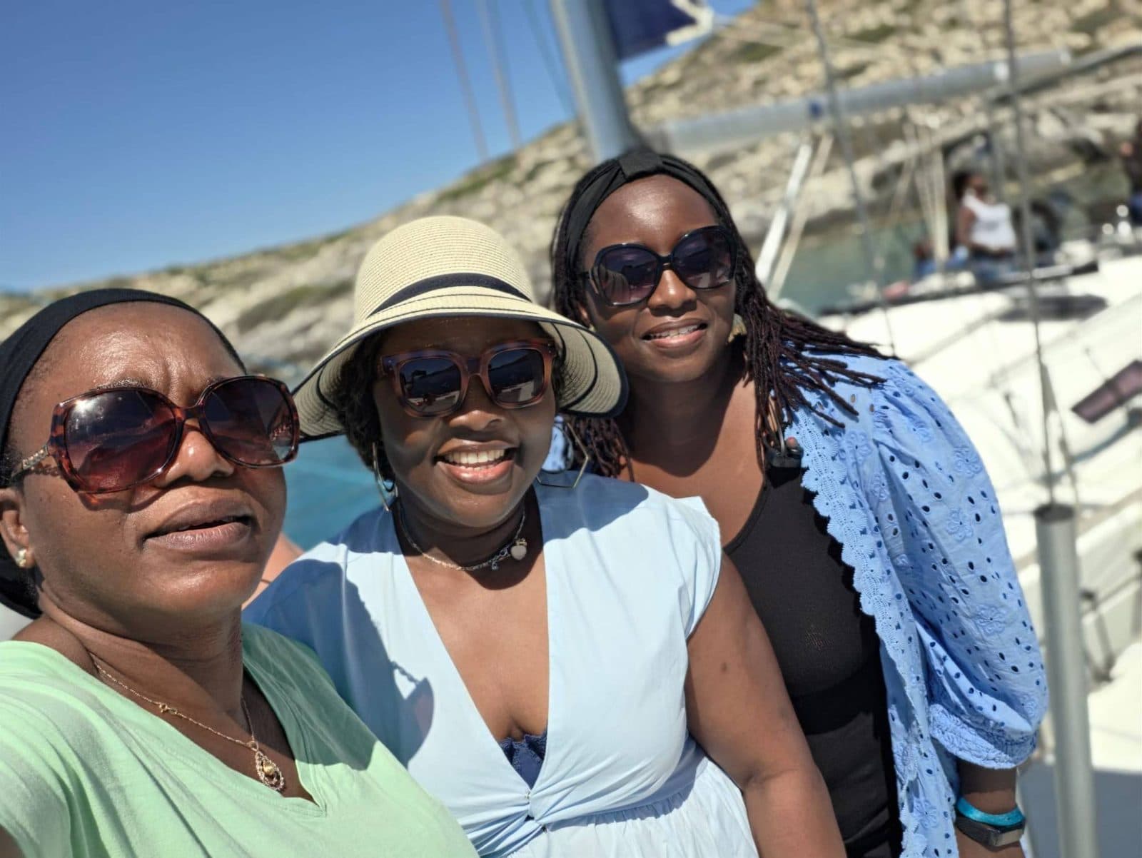 Three women smiling on the deck of a boat